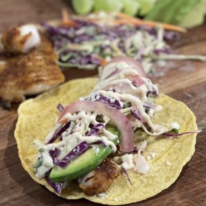 Fish taco with pickled red onions cabbage slaw avocado and a creamy dressing